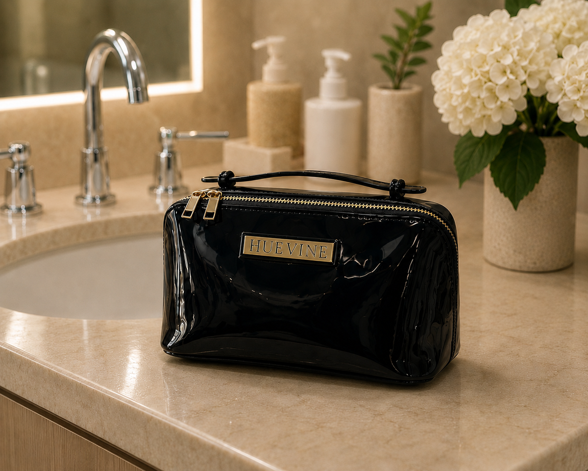 HueVine Glow Bag displayed on a luxury bathroom counter beside a sink in an elegant skincare setting.